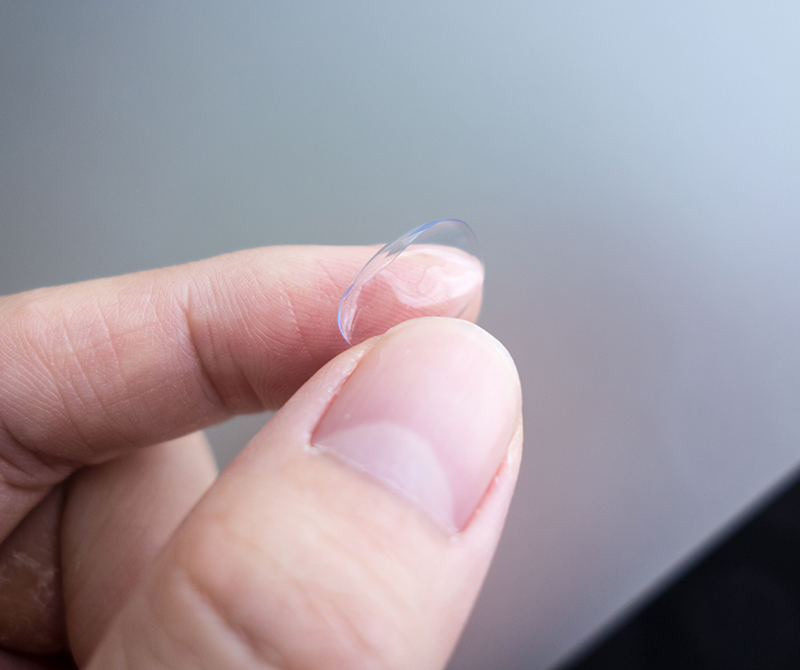 Person holding on to ripped contact lenses.