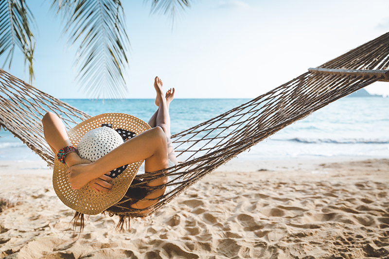 Woman relaxing on hammock at the beach.