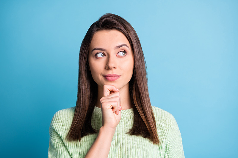 Woman thinking against blue background.