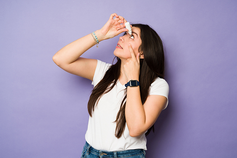 Woman using eye drops
