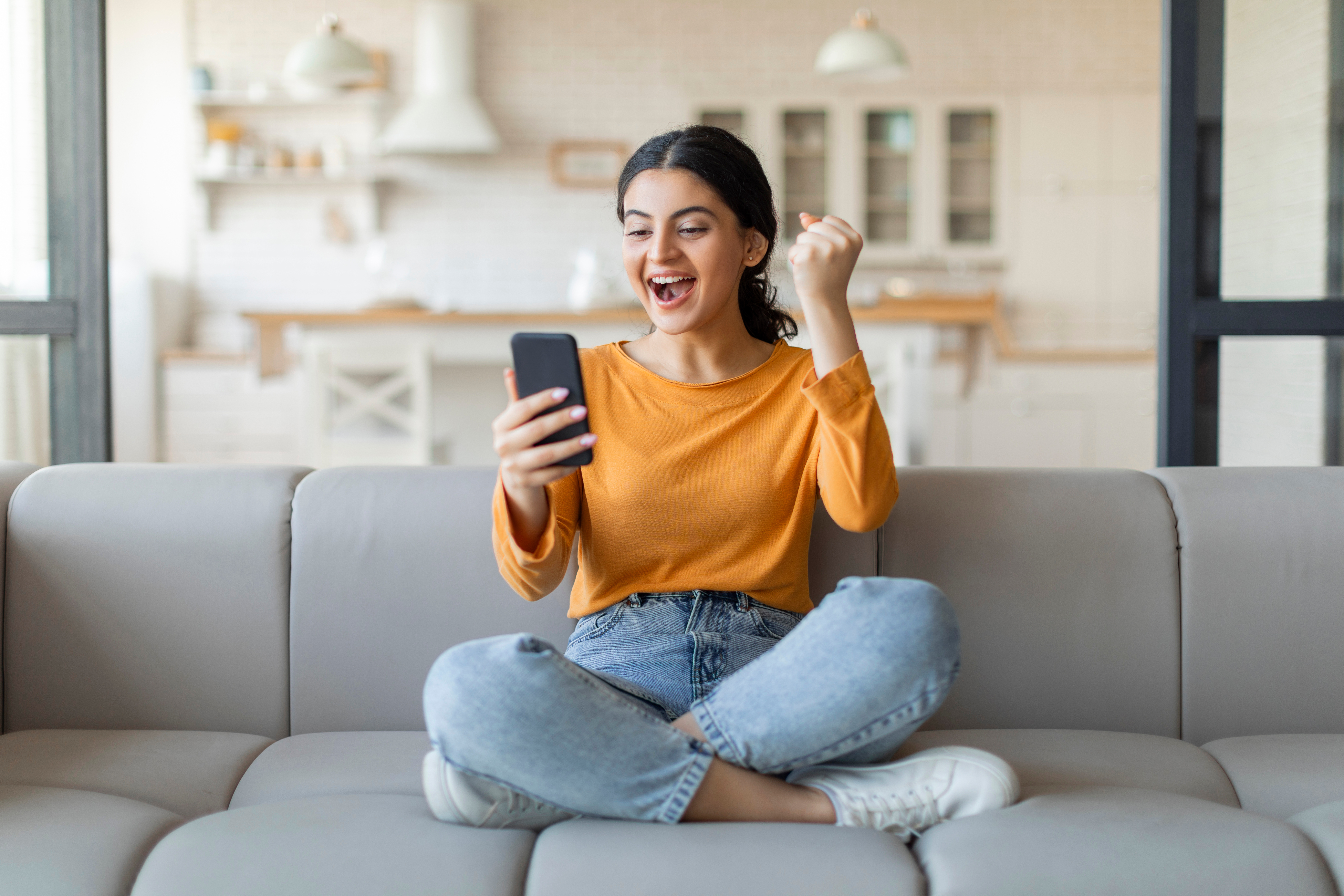 Young woman celebrating after finding a contact lens offer on her phone