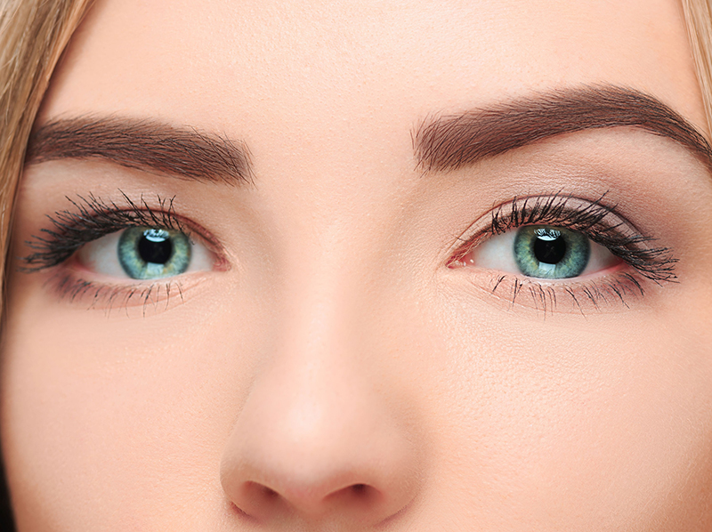 An image of a close up of a woman’s face with blue eyes