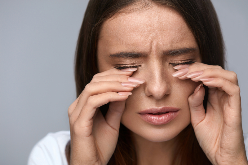 Close up of brunette woman rubbing both her eyes with each hand